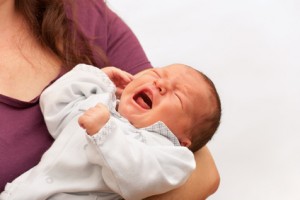 Newborn baby crying in his mother's arm