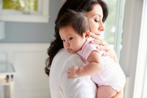 Loving Mother Holding Baby Daughter At Home